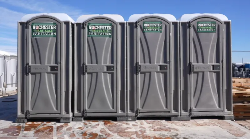 Row of four gray Rochester Portable Sanitation porta potties lined up for rental in Rochester, NY