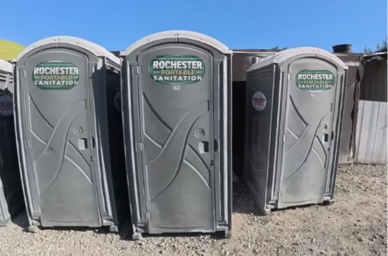 Three Rochester Portable Sanitation porta potties in a row, ready for rental in Swillburg, Rochester NY
