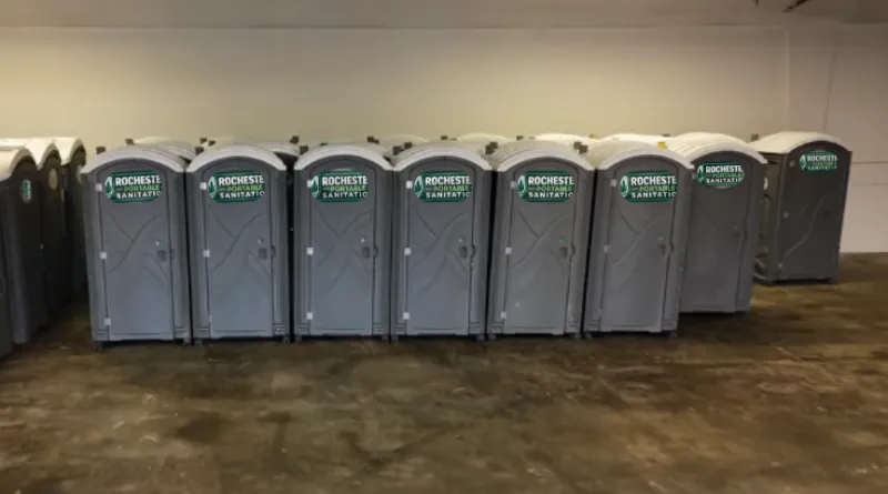 Row of gray Rochester Portable Sanitation porta potties lined up and ready for rental in Rochester, NY
