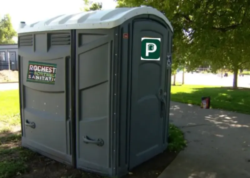 Rochester Portable Sanitation porta potty on a paved path beside a park lawn, available for rental in Cobbs Hill, Rochester NY
